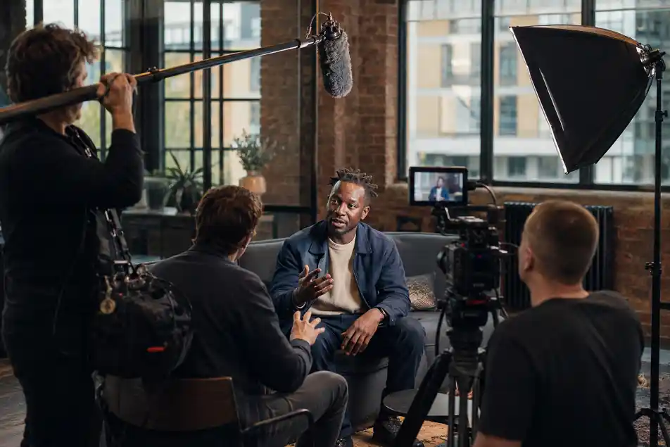 Production team conducting an interview setup in a naturally lit Manchester office, documentary production Manchester, factual programming, brand documentary